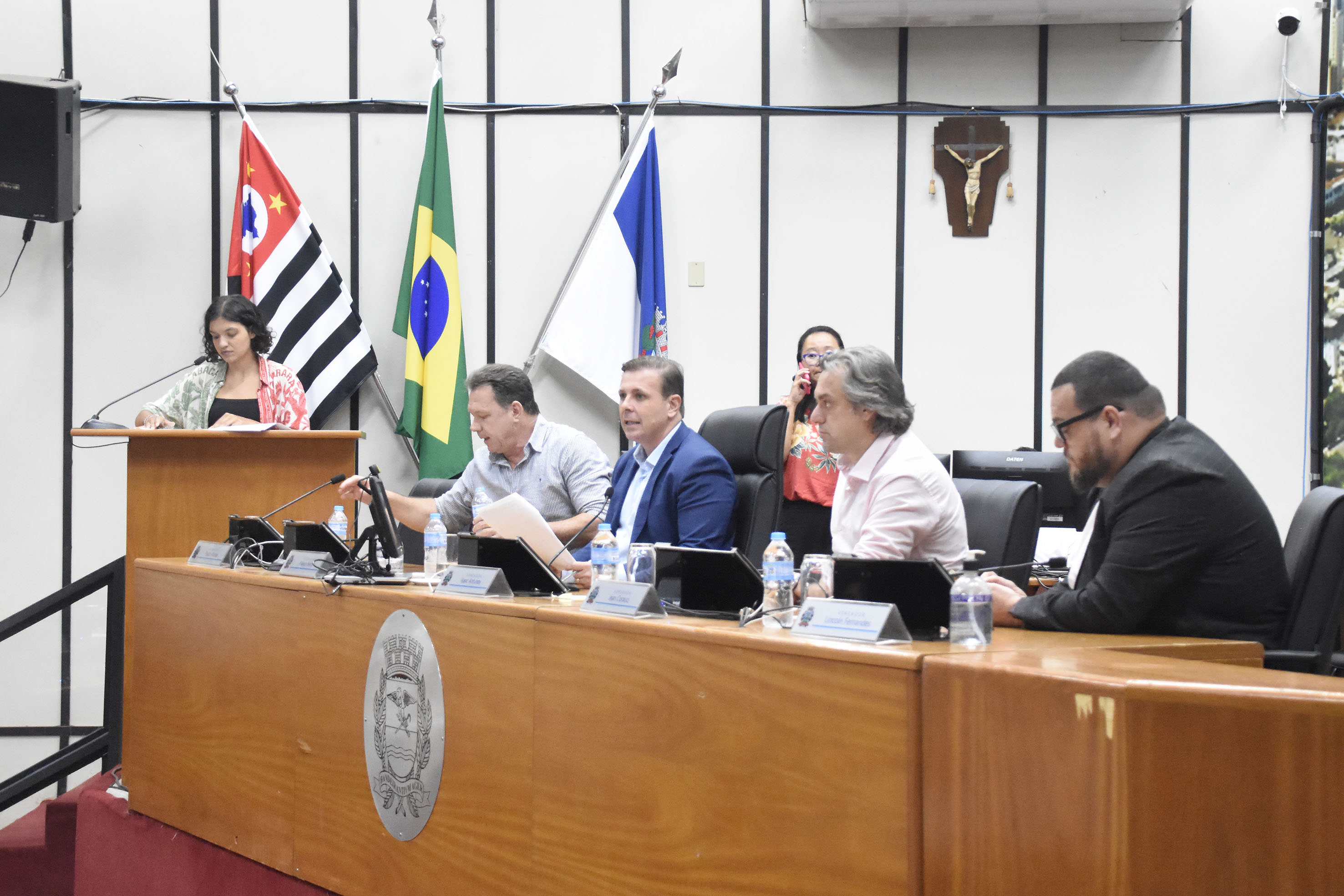 Imagem fechada da Mesa Diretora com a vereadora Duda na tribuna